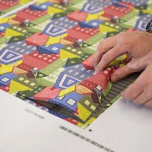 Präzise lasergeschnittene, bedruckte Textilien werden direkt nach dem Zuschnitt von der eurolaser Lasermaschine entnommen