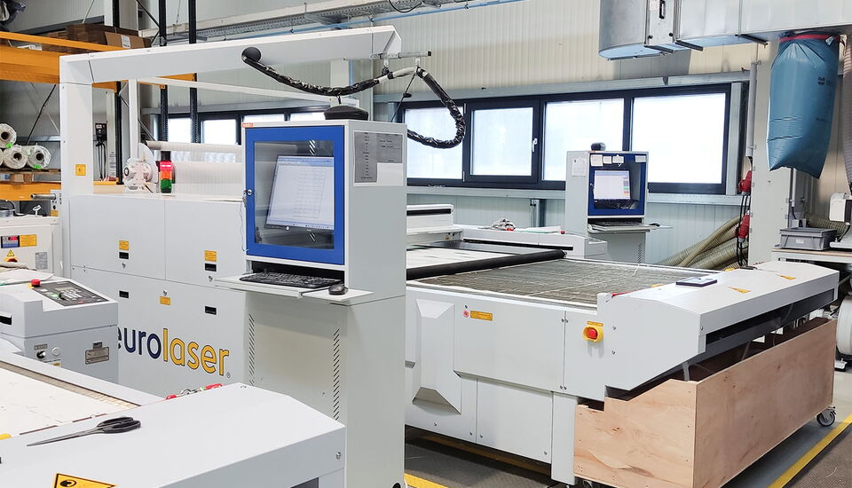 Máquina láser de corte CO₂ de eurolaser en Koestler para el procesamiento rápido y fiable de bisagras de airbag, tejidos de refuerzo y plantillas de prueba con un alto nivel de automatización