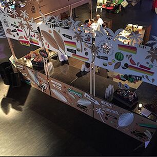 Designorientierter Verkaufsstand mit bedruckter und passgenau lasergeschnittener Holzfassade, umgesetzt durch präzises Laserschneiden auf einer modernen Laserschneidmaschine mit vielen filigranen Details