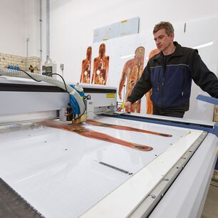 Kontaktfreier Laserzuschnitt von bedrucktem Acrylglas bei der Gubener Plastinate GmbH mit einer eurolaser Laserschneidmaschine für präzise und kristallklare Schnittkanten