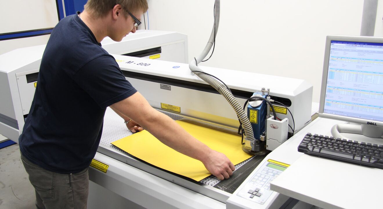 Un empleado de Rohde & Schwarz carga la cortadora láser de CO₂ de eurolaser – preparación precisa para el procesamiento de materiales