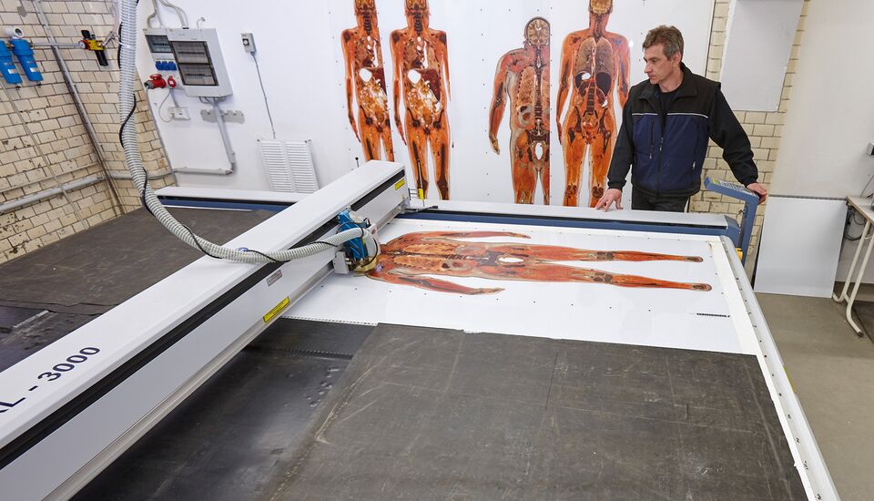 Placa de acrílico impresa en gran formato durante el corte por láser de precisión en la producción de Gubener Plastinate con la máquina de corte por láser eurolaser XL-Line